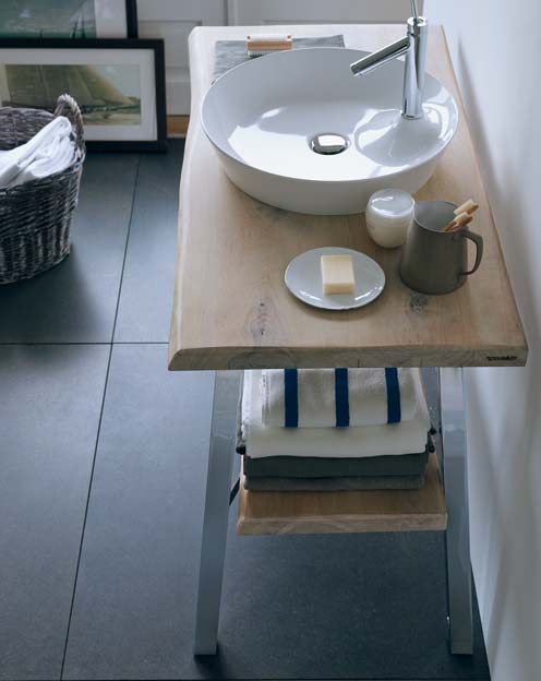 Un lavabo sur une planche en bois dans une salle de bains de style naturel