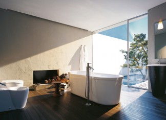 Un sol en bois, des murs peints et une baignoire îlot, collection Starck 1 de Duravit (robinetterie chez Axor-Hansgrohe). une salle de bains de style naturel