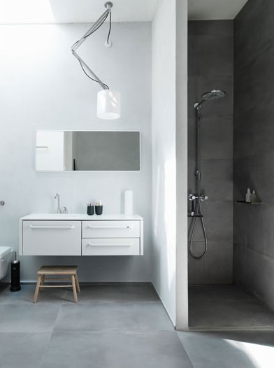 Une salle de bains de style scandinave, très blanche et épurée, avec un tabouret en bois