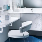 Une coiffeuse dans une salle de bains blanche qui prolonge le meuble-vasque
