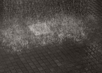 eau éclaboussant sur le sol d'une douche carrelée
