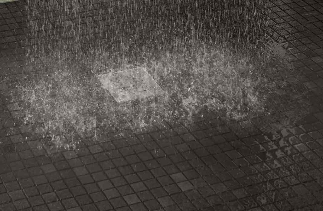 eau éclaboussant sur le sol d'une douche carrelée