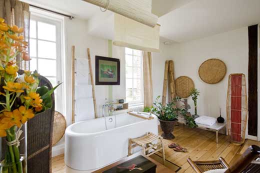 Une salle de bains de style japonais, avec sa baignoire îlot et les nombreux accessoires en bambou