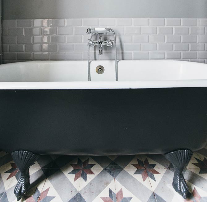 Une salle de bains au charme rétro, avec baignoire sur carreaux de ciment