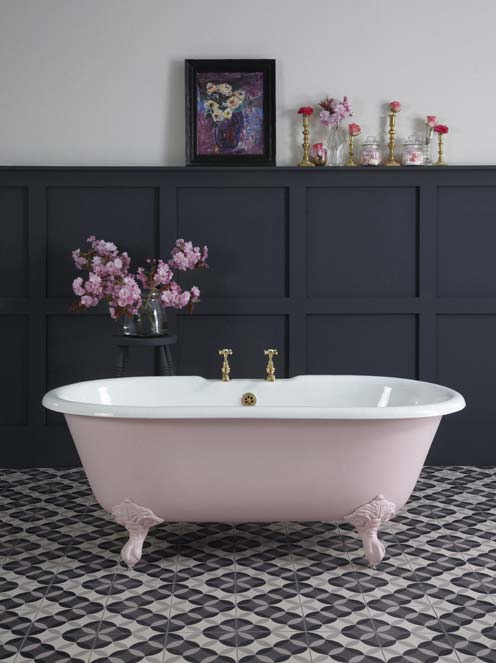 Une salle de bains de style anglais, avec une baignoire rétro rose