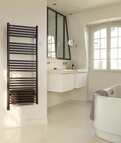 Un sèche-serviettes échelle noir avec un soufflant dans une salle de bains blanche
