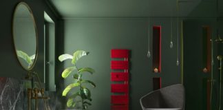Une salle de bain verte avec un sèche-serviettes avec soufflant rouge