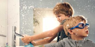 Enfants jouant avec l'eau devant le lavabo