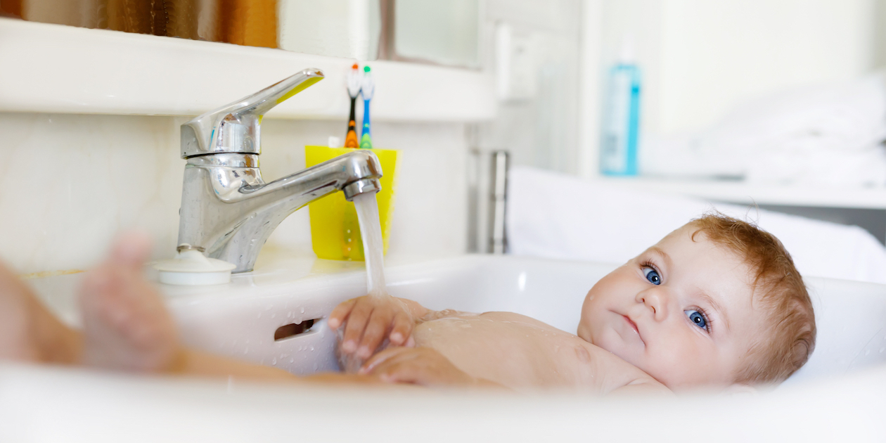 bébé prend un bain dans le lavabo