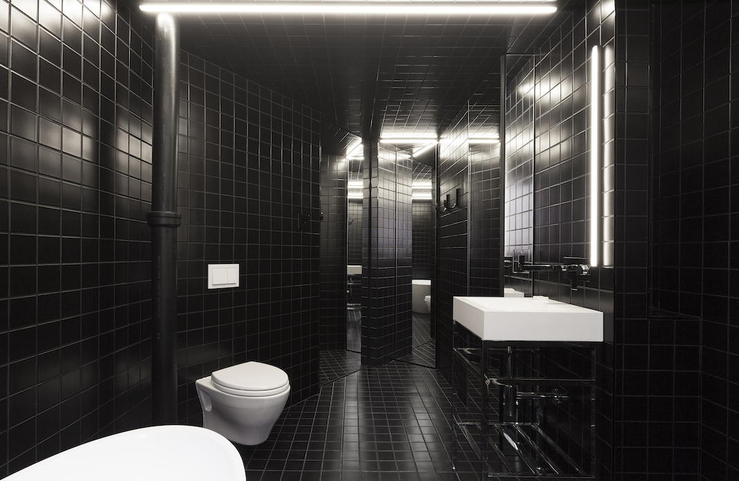 salle de bains entièrement carrelée avec des carreaux noirs