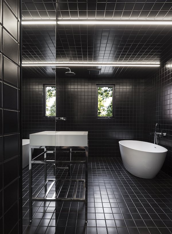 salle de bains toute carrelée avec des carreaux noirs