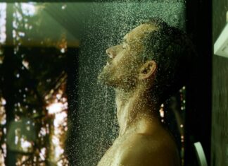 Homme sous une douche de tête Hansgrohe