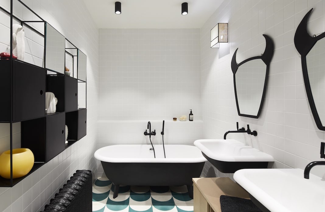 salle de bain design avec une baignoire et des lavabos noirs dehors et blancs dedans