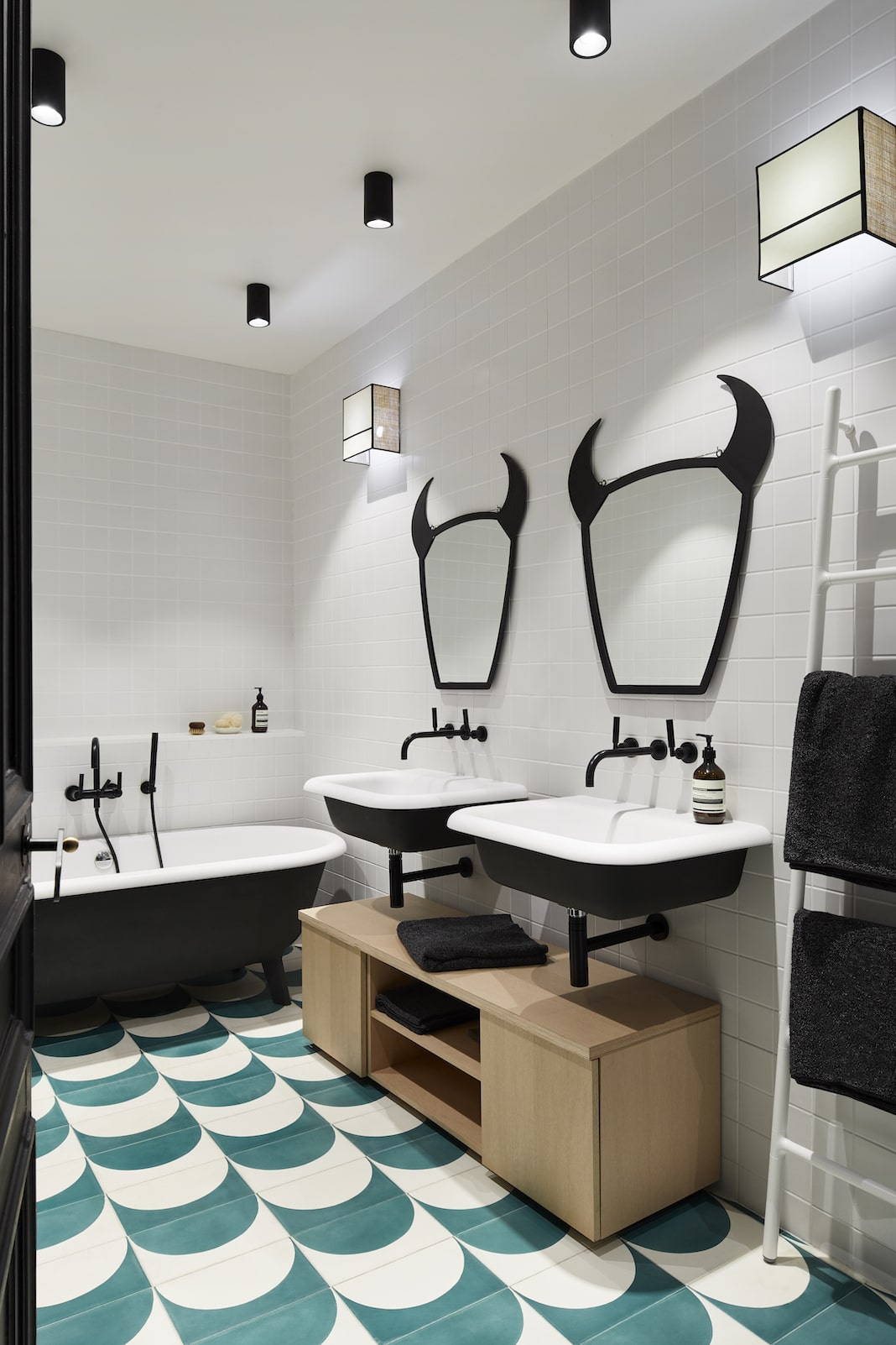 salle de bain design noire et blanche avec des miroirs cornus au dessus des lavabos