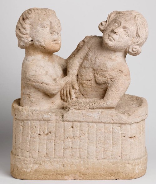 sculpture ancienne de deux personnes dans un bain