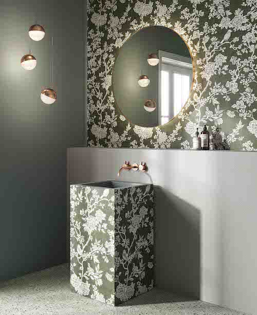 salle de bains avec un carrelage de fleurs blanches sur fond vert