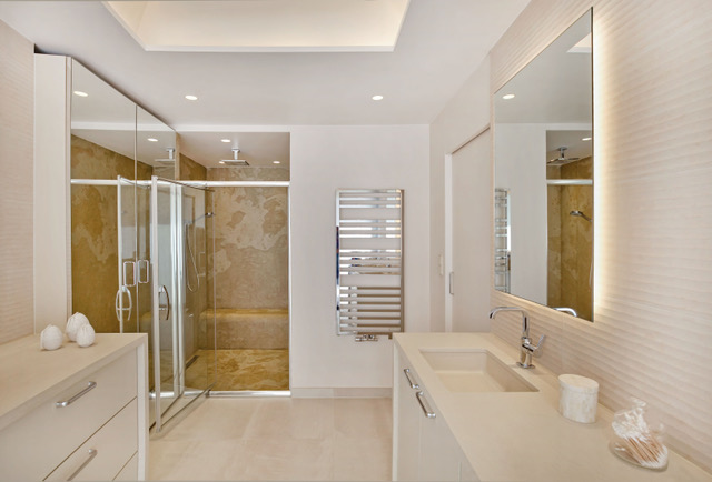 Une salle de bains ivoire, avec une douche revêtue de feuille de pierre