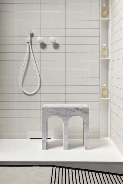 Petit banc Antoniolupi en marbe blanc dans la douche