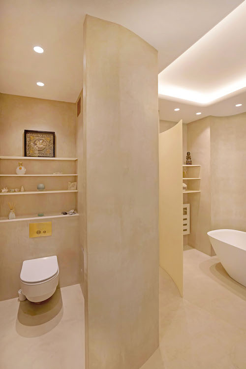 Les toilettes et la salle de bains revêtues de béton ciré beige