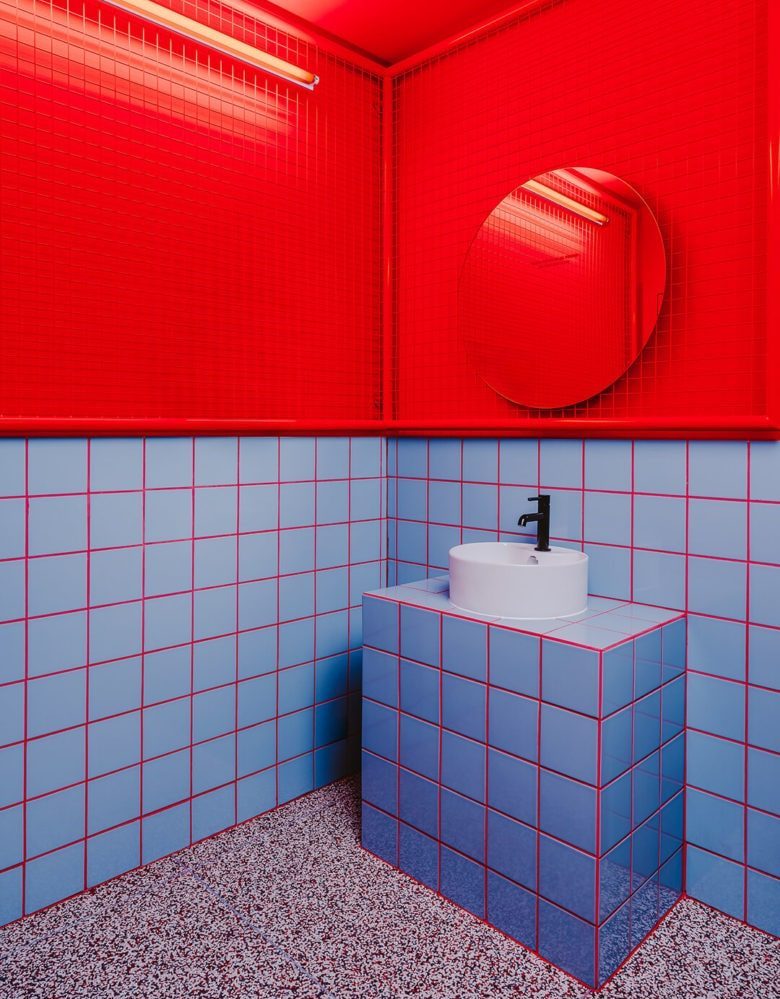 salle de bains avec des carreaux bleus et des joints rouges