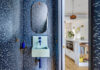 Dans des toilettes bleues, un lavabo mural bleu et sa robinetterie bleu foncé