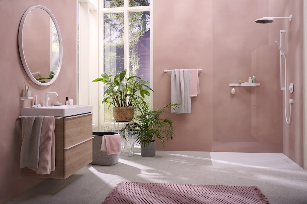 Salle de bains aux murs roses, avec des robinets blanc mat.